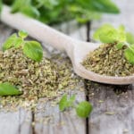 Oregano,On,A,Wooden,Spoon,(against,Wooden,Background)