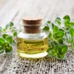 Oregano,Plant,With,Essential,Oil,On,Wooden,Background